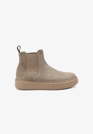 Stivali alla caviglia in suede beige con pannelli laterali elastici, linguetta e suola in gomma marrone solida. Texture liscia con dettagli di cucitura minimi.