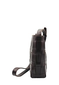 Sac à main tissé en cuir brun avec une forme structurée, un fond plat, une sangle fine et une poignée supérieure. Surface textur ée avec des carrés distincts.