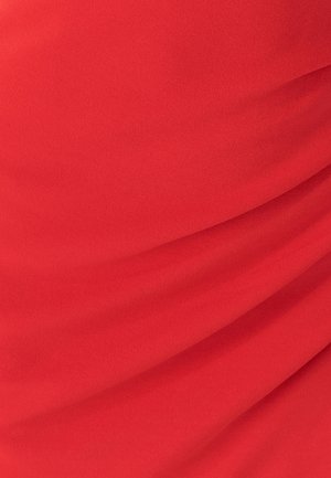 Crveni materijal s mekim, glatkim teksturom, s nježnim nabiranjem i naborima koji stvaraju suptilnu dubinu i pokret.