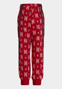 Pantalones de chándal rojos con un patrón repetido de letras 'M' blancas y cabezas de Mickey Mouse amarillas, con franjas laterales negras y puños acanalados.