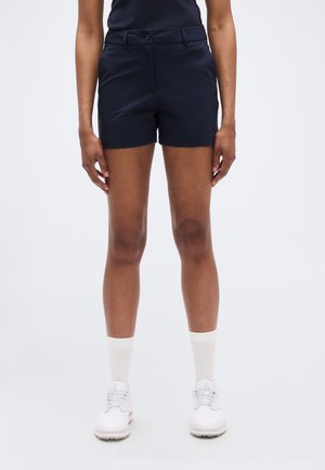 Marineblå shorts med skreddersydd passform, frontlommer, knappelukking og glatt stoff. Brukes med hvite joggesko og lyse sokker.