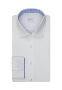 Camicia bianca con colletto e polsini foderati a fantasia blu, piegata ordinatamente con i bottoni visibili e una tasca sul lato destro.