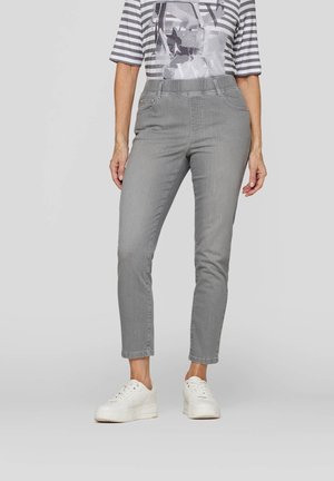 Gray fitted pants with a sleek finish and five pockets, matched with a striped gray and white T-shirt and white sneakers.