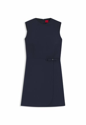 Robe sans manches bleu marine avec un col rond, des poches latérales et un petit détail ceinture à la taille. Tissu lisse avec une coupe ajustée.