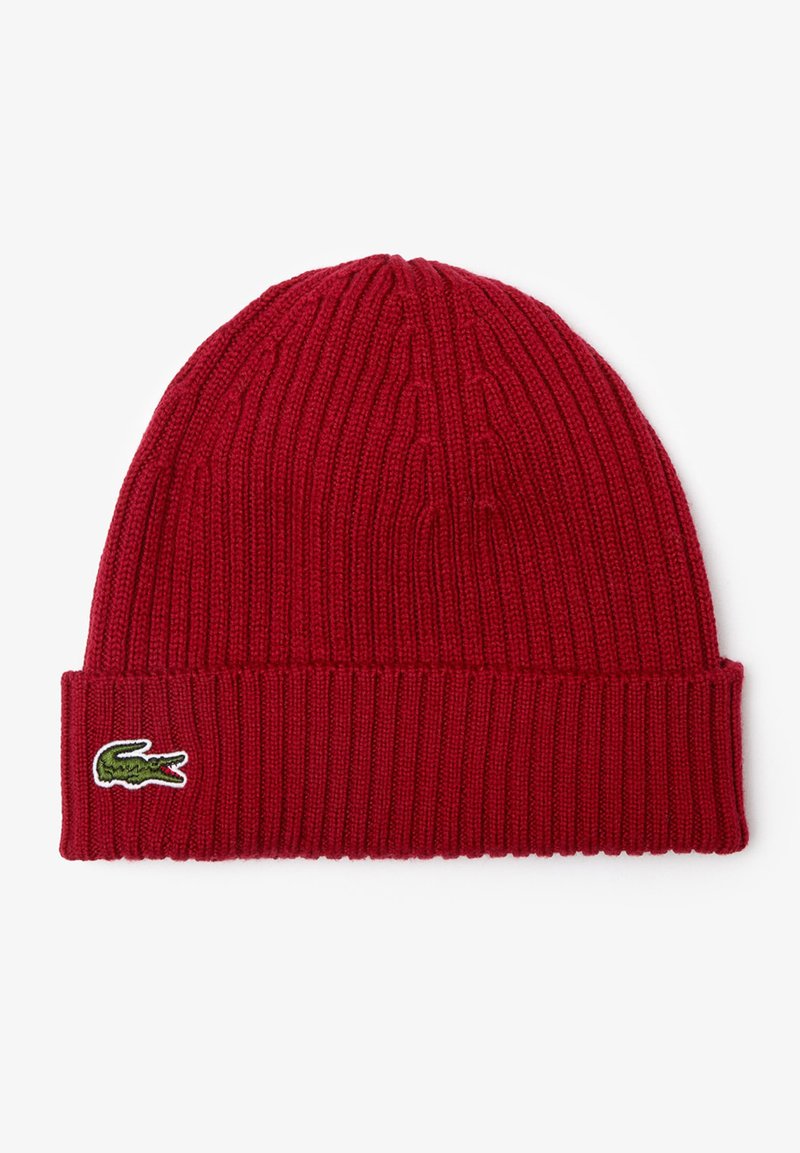 Rode gebreide beanie met geribbelde textuur, voorzien van een omgeslagen rand en een klein geborduurd groen krokodillogo aan de zijkant.