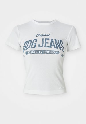 Bela bombažna majica s kratkimi rokavi, ki prikazuje modre vintage grafike z napisom "Original BDG Jeans Quality Goods" in dvema majhnima luknjama na robu.