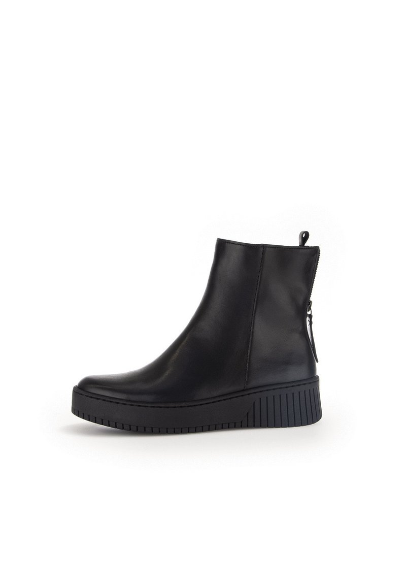 Botas negras de cuero hasta el tobillo con un diseño elegante, que cuentan con un cierre lateral y una suela de goma texturizada para mayor agarre. Acabado suave, forma moderna.