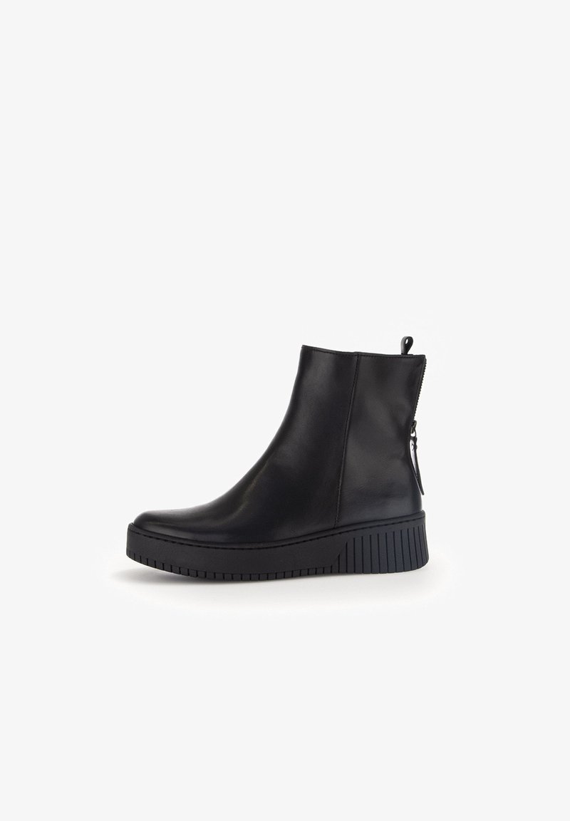 Zwarte leren enkelboots met een slank ontwerp, voorzien van een zijrits en een gestructureerde rubberen zool voor grip. Gladde afwerking, moderne vorm.