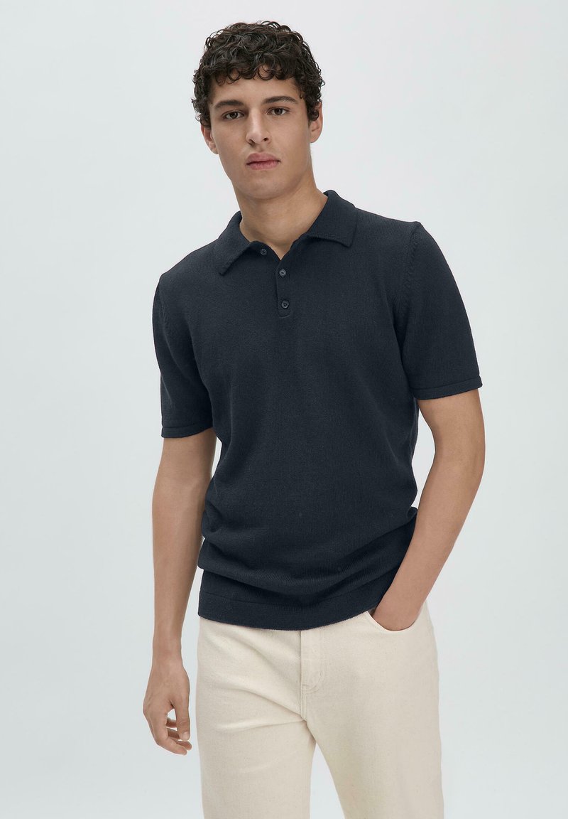 Navy short-sleeve polo shirt with a classic collar and three-button placket, made from a smooth, lightweight fabric.