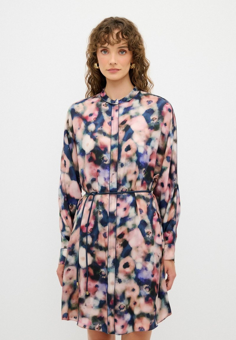 Långärmad klänning i lätt tyg med ett flerfärgat blommönster, krage och midja med dragsko och guldfärgade detaljer.