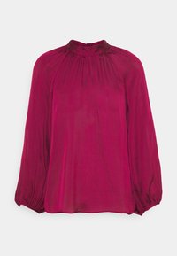 Blusa magenta a maniche lunghe con colletto alto e dettagli arricciati sullo scollo. Realizzata in un tessuto morbido e semitrasparente.