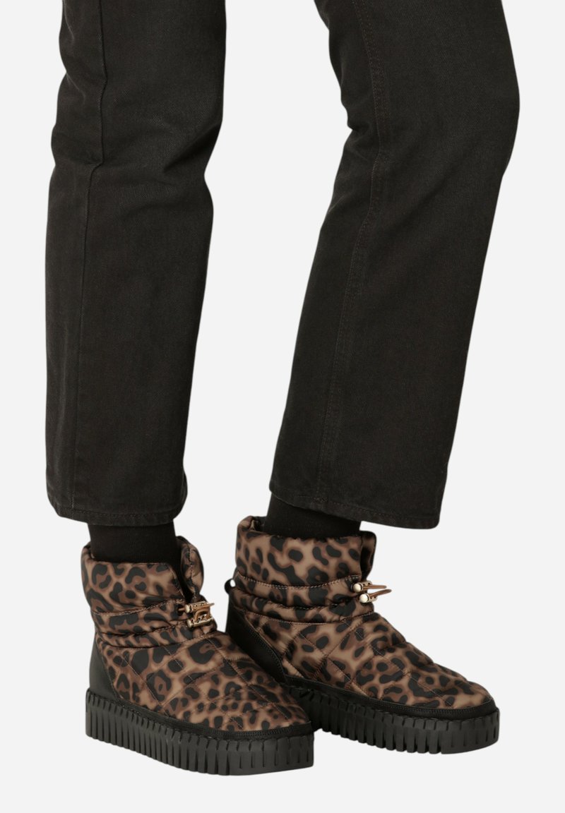 Botas acolchadas con estampado de leopardo y suela de goma negra, que presentan un diseño de puño doblado y acentos de hardware en tono dorado.