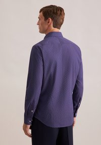 Camicia blu navy con motivo geometrico, dotata di maniche lunghe, colletto a punta e orlo curvo. Tessuto morbido, di peso medio.