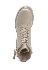 Stivale alla caviglia beige con lacci, texture in pelle liscia, punta arrotondata e dettaglio con zip laterale. Suola spessa con bordo scanalato.