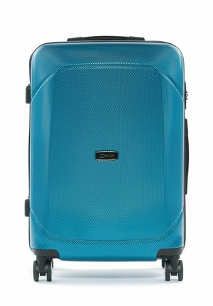 Średniej wielkości twarda walizka w teksturowanym niebieskim kolorze z czterema czarnymi kołami obrotowymi i uchwytem na górze.