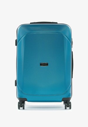 Średniej wielkości twarda walizka w teksturowanym niebieskim kolorze z czterema czarnymi kołami obrotowymi i uchwytem na górze.