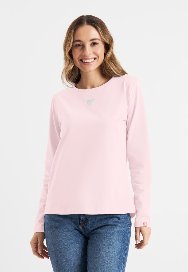 Helles rosa Langarmshirt mit einem kleinen Herzdesign auf der Brust. Hergestellt aus glattem Stoff mit rundem Ausschnitt und entspannter Passform.