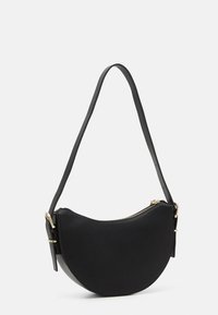 Sac à main en cuir noir avec une forme incurvée, fermeture éclair dorée et bandoulière ajustable. Présente une surface texturée et un design minimaliste.