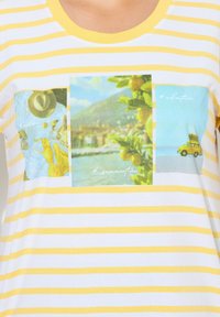 Raidallinen lyhythihainen t-paita keltaisesta ja valkoisesta puuvillasta. Siinä on kolme värikästä painatusta, jotka kuvaavat lomateemoja. Pyöreä pääntie.