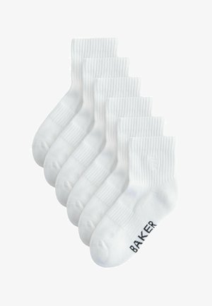 Šesť párov bielych rebrovaných ponožiek s nápisom "BAKER" na chodidle predného páru, naskladaných na sebe.