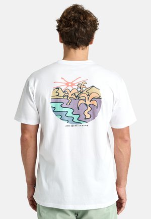 Camiseta blanca de algodón con un diseño abstracto colorido en la parte posterior, que representa montañas, palmeras y un sol sobre el agua.