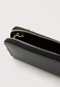 Portofel negru cu exterior texturat, fermoar auriu și interior spațios cu atașament pentru breloc.