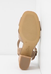 Sandale avec une semelle beige, un talon bloc et des brides en daim, vue par le dessous montrant la taille 37 et la marque "s.Oliver".
