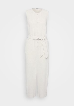 Sleeveless linen jumpsuit in light beige with a button front, belted waist, and cropped legs featuring roll-up cuffs. Smooth texture.