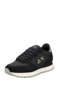 Zapatilla atlética de ante negra con un acabado suave, que presenta acentos dorados y cordones, una media suela blanca y un diseño de puntera redondeada.