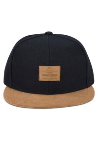 Musta lippalakki, jossa on vaaleanruskea mokkanahkakehys. Varustettu suorakaiteen muotoisella ruskealla nahkapatchilla, jossa on kohokuvioitu brändin nimi ja logo. 100 % puuvillakangasta, rakenteellinen muotoilu.