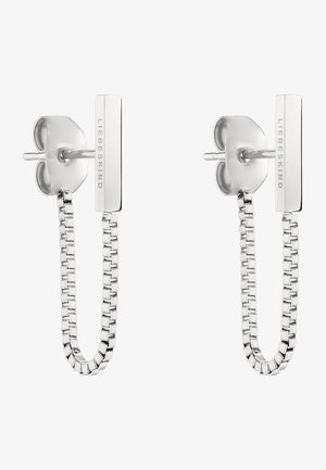 Boucles d'oreilles en chaîne argentée avec un clou en forme de cœur et une barre rectangulaire portant une marque gravée, affichant une finition brillante et lisse.