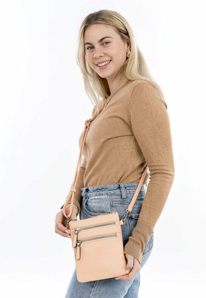 Crossbody bag in soft peach leather, featuring three zippered compartments and a long adjustable strap. Smooth texture, minimalistic design.