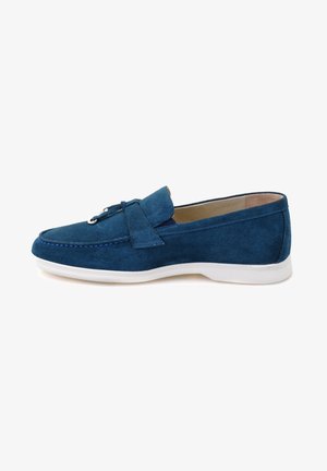 Blue suede loafer with a soft texture, white rubber sole, decorative tied accent on the front, and detailed stitching along the edges.