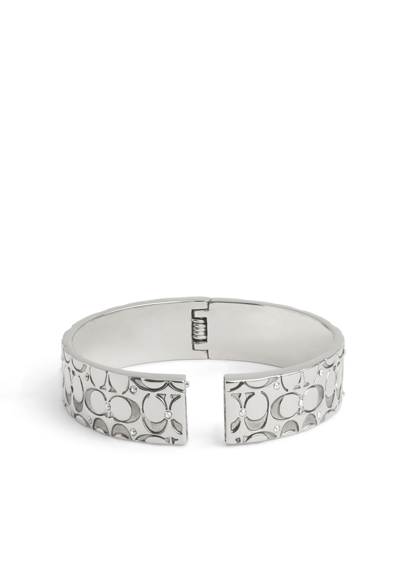 Bracciale a manichetta in argento con motivi circolari incisi e piccoli chiodini. Dotato di una chiusura a cerniera per una facile indossabilità. Texture liscia, finitura lucida.