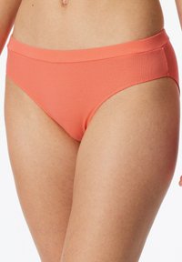 Koraalkleurige bikini onderkant met een geribbelde textuur, voorzien van een brede tailleband en een klassieke snit die comfortabel op de heupen zit.