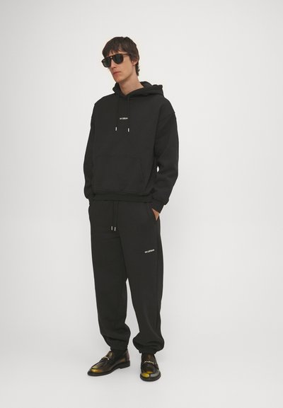 Han Kjøbenhavn DAILY UNISEX - Tracksuit bottoms - black