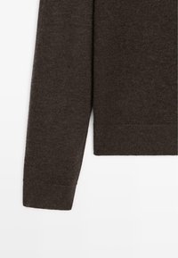 Brown wool sweater sleeve featuring a ribbed cuff, smooth texture, and basic design with a straight cut and subtle knit pattern.
