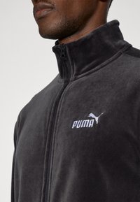 Μαύρο fleece μπουφάν με ψηλό γιακά και πλήρες φερμουάρ. Διαθέτει κεντημένο λευκό λογότυπο Puma στο αριστερό στήθος. Μαλακή υφή.