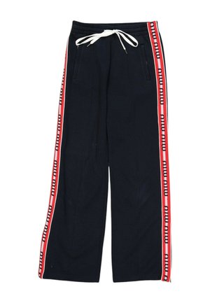 Zwarte wijde broek met witte aantrekkoord in de taille en rode zijstrepen met herhaalde zwarte tekst.