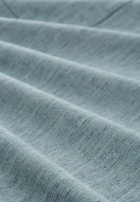 Tejido azul claro con una textura suave y un patrón sutil y variado. La tela muestra suaves ondulaciones y un acabado liso.