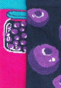 Calcetines coloridos con un fondo rosa y una ilustración de un tarro, y un fondo oscuro con patrones de arándanos morados. Tejido de punto, grosor medio.