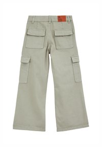 Gai pelēki cargo bikses ar plašām kājām, daudzām kabatām un brūnu birku muguras jostā. Izgatavotas no izturīga auduma.