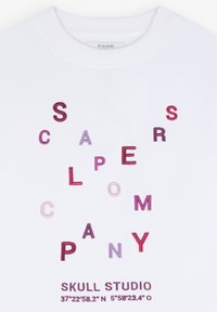 Biała bluza z kolorowymi, haftowanymi literami tworzącymi napisy "SCALPERS COMPANY" oraz "SKULL STUDIO" z współrzędnymi na dole.