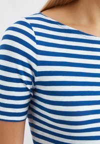 Blue and white striped short-sleeve top with a round neckline, featuring a fitted design and soft, textured fabric.
