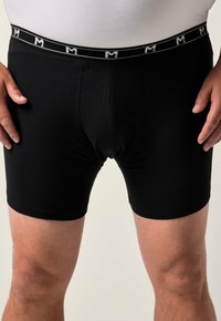 Boxer brevissimi neri realizzati in un tessuto liscio, con una fascia elastica branded bianca e lettere a contrasto. Design aderente.