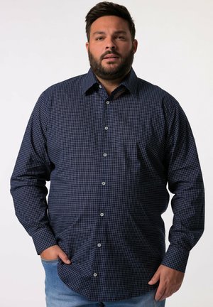 Camisa de cuadros azul marino con mangas largas, cuello abotonado y bolsillo frontal. Fabricada con tejido entrelazado, con botones blancos.