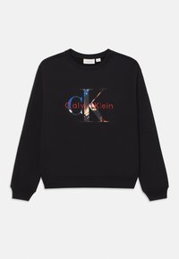 Felpa nera in cotone con collo rotondo. Presenta un logo "CK" colorato e la scritta "Calvin Klein" in rosso, centrata sulla parte anteriore.