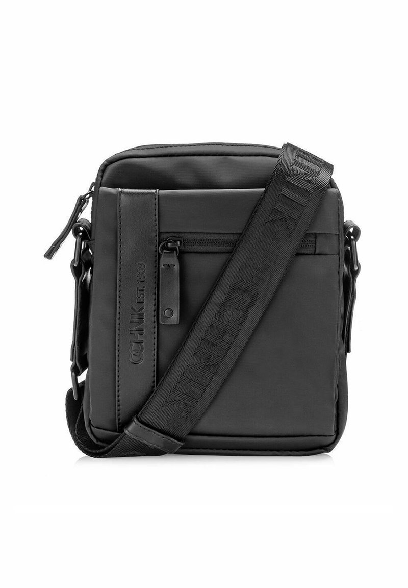 Czarna torebka na ramię wykonana z wytrzymałego materiału, z zamykaną na zamek przednią kieszenią oraz regulowanym paskiem z wytłoczonym logo. Prostokątny kształt.