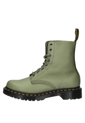Green leather combat boot with six eyelets, a black rubber sole, yellow stitching, and a pull tab at the back. Textured surface detailing.