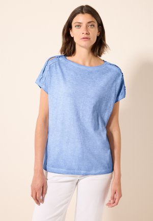Light blue, short-sleeve top made of soft fabric, featuring a relaxed fit, subtle shoulder cutouts, and button accents on the sleeves.